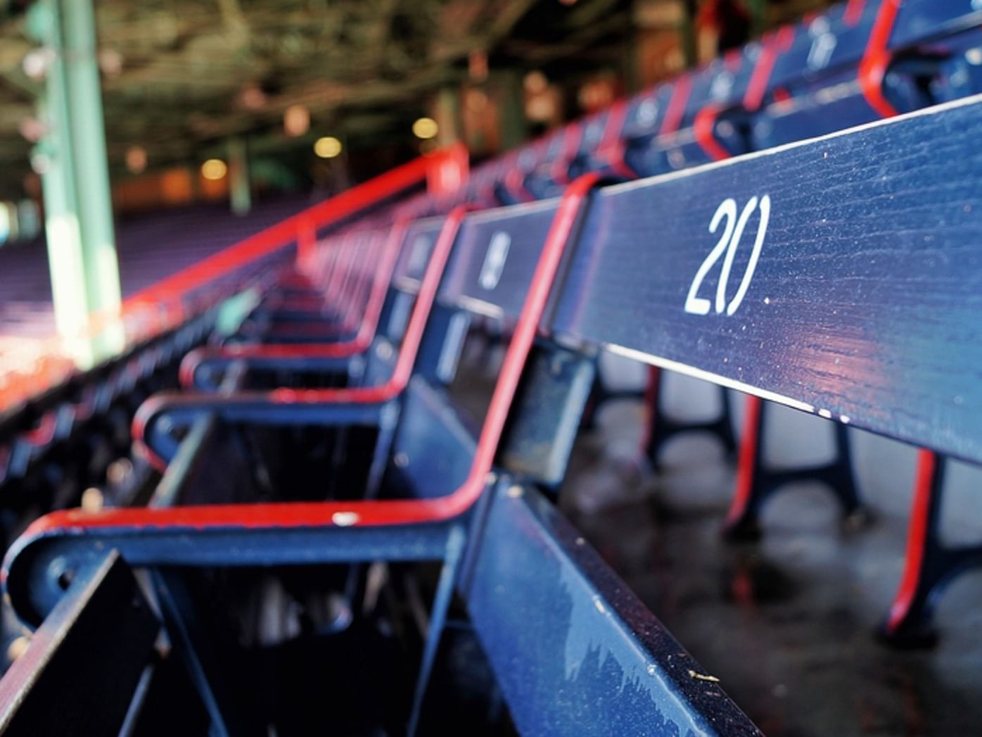 Close-up of empty blue stadium seats with the number 20 marked on one of them.