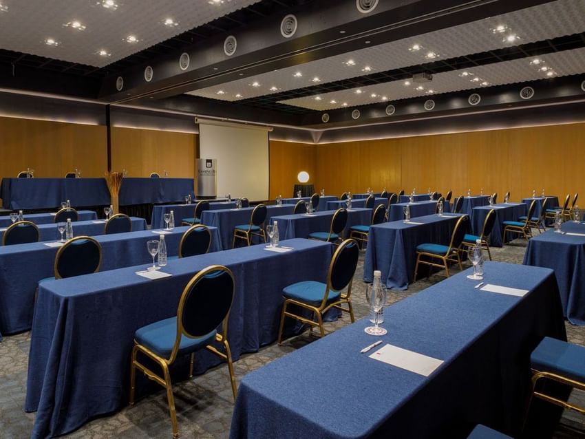 Sala de eventos Camino Real con mesas y sillas azules en el Camino Real Aeropuerto México en Ciudad de México.