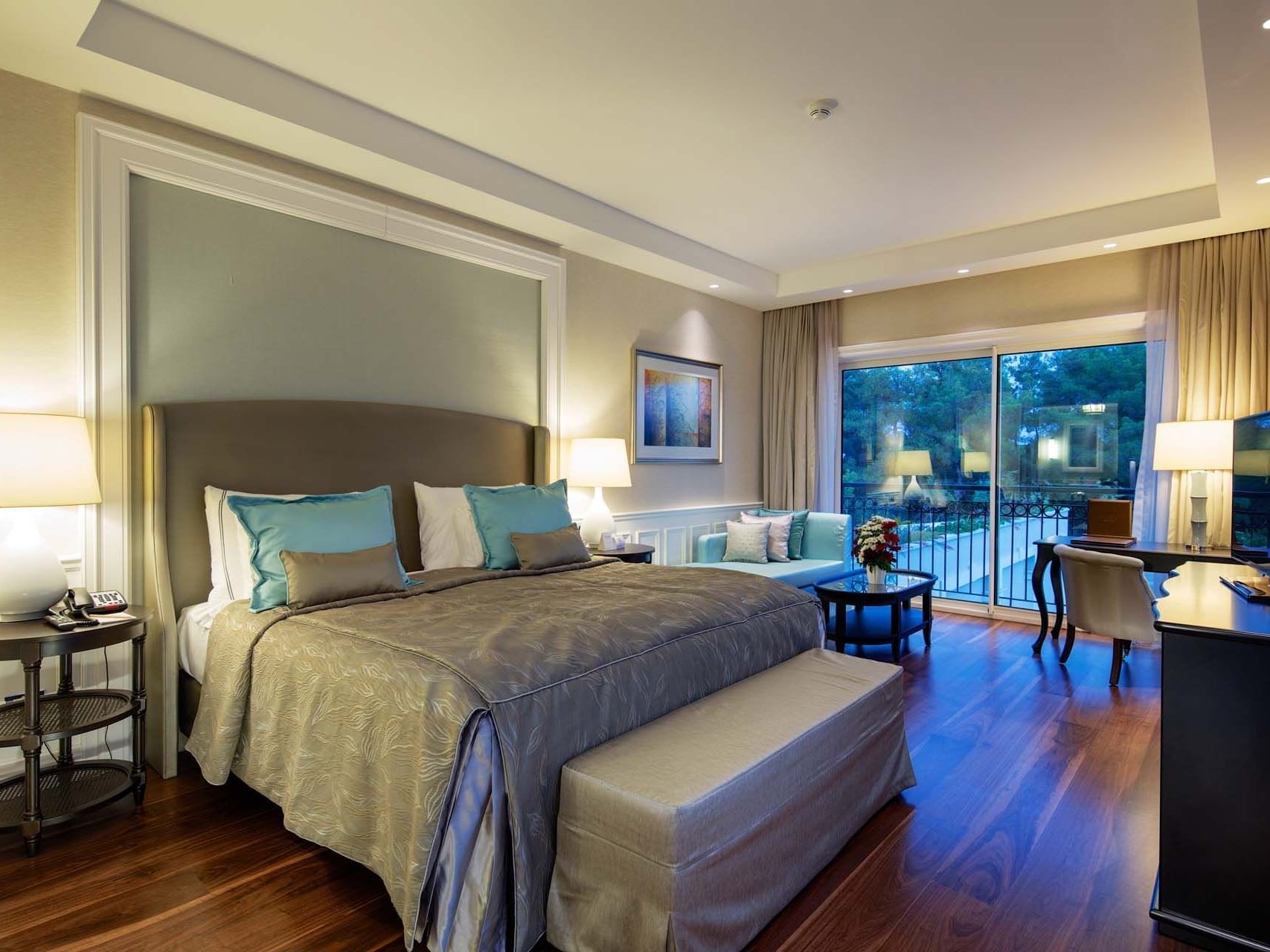 Sitting area & work desk by the bed in Design Pool Villa with wooden floors at Titanic Deluxe Golf Belek