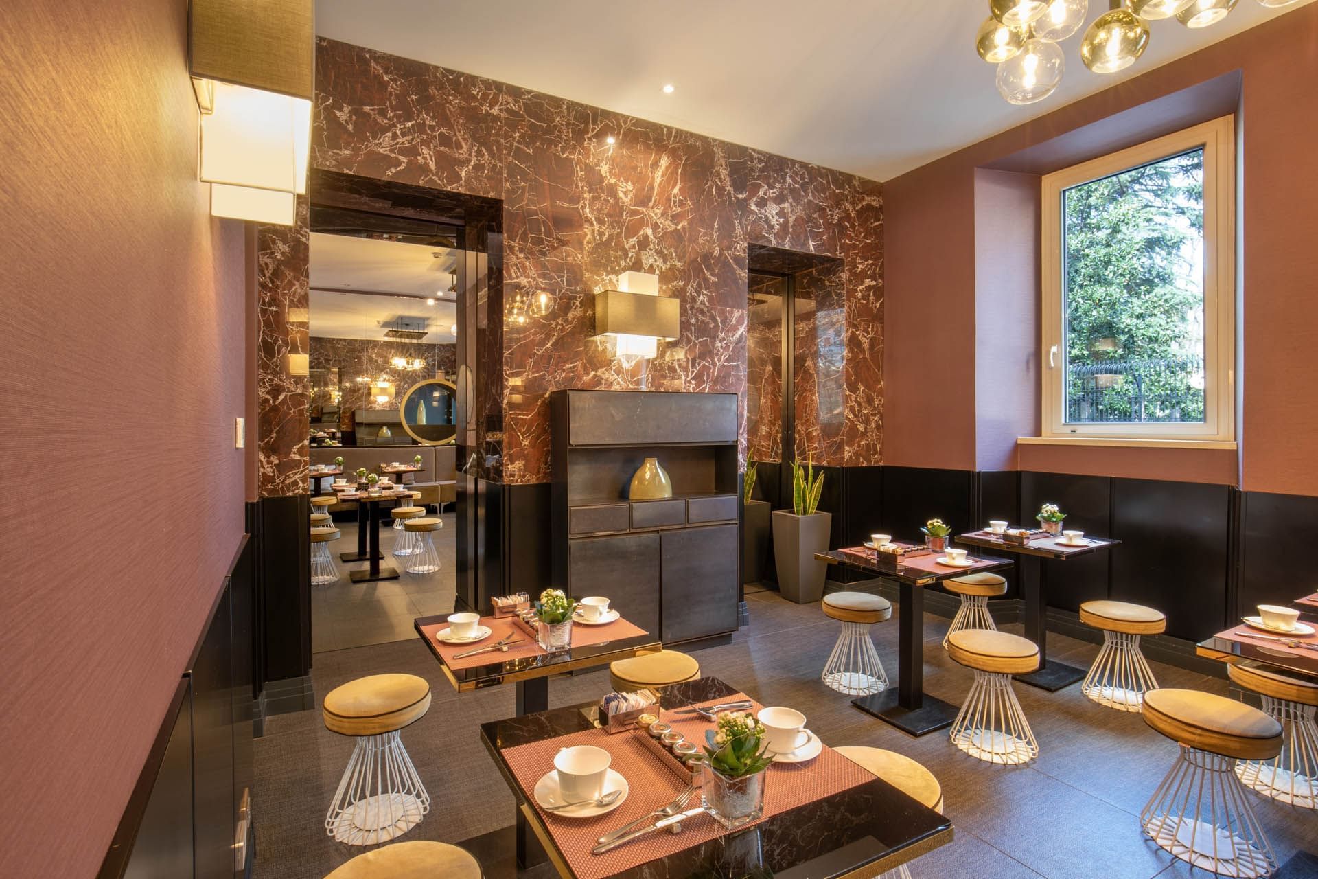 Elegant Breakfast restaurant at The Guardian Hotel with modern tables, stylish decor, and windows overlooking greenery