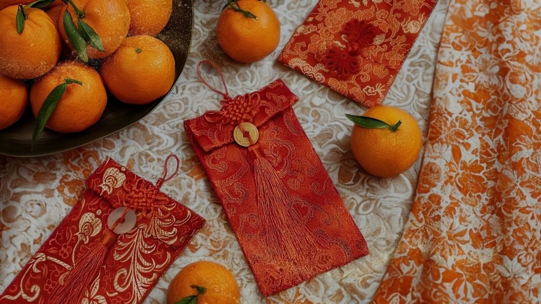 Oranges and traditional red pouches on a patterned cloth promoting A Season of Harmony.