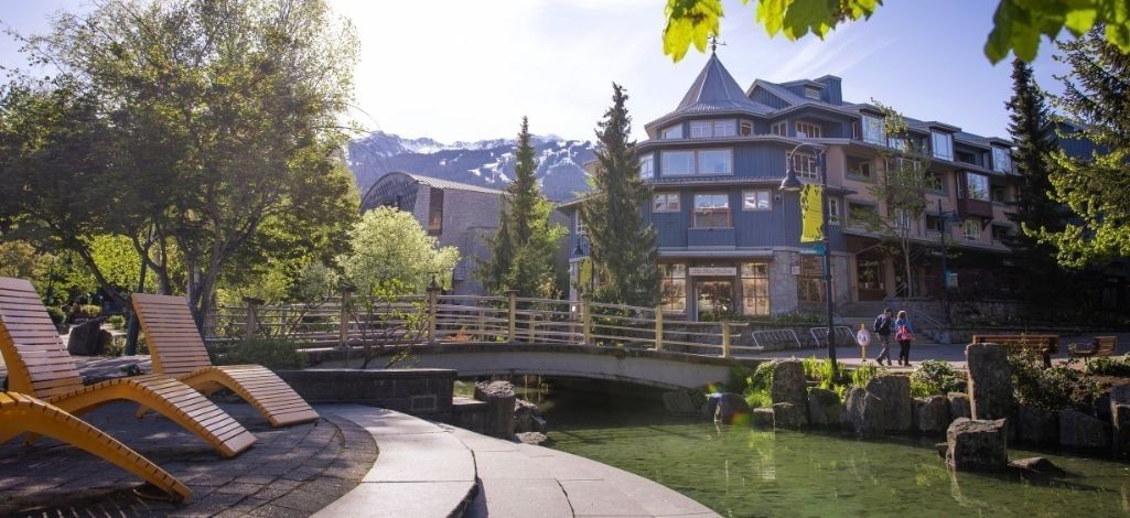 Whistler Village walkway near hotel buildings, mountain views and outdoor seating
