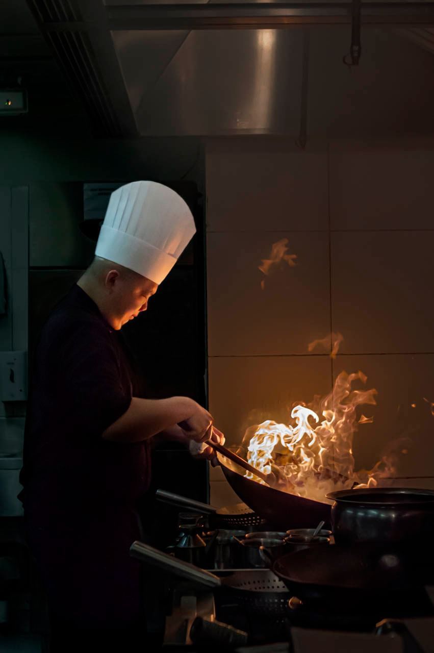 Chef cooking using a wok at Vasa Hotel Surabaya