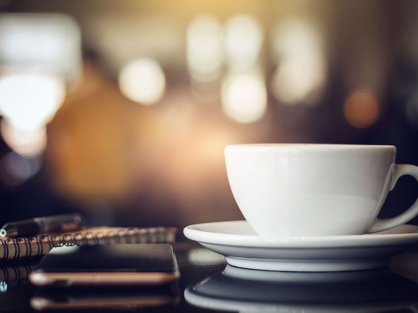 A cup of coffee with a smartphone on a table, cafe at The Nest