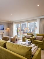 Decorated penthouse living room with green furniture and city view at The Capital Hotel, Apartments & Townhouse