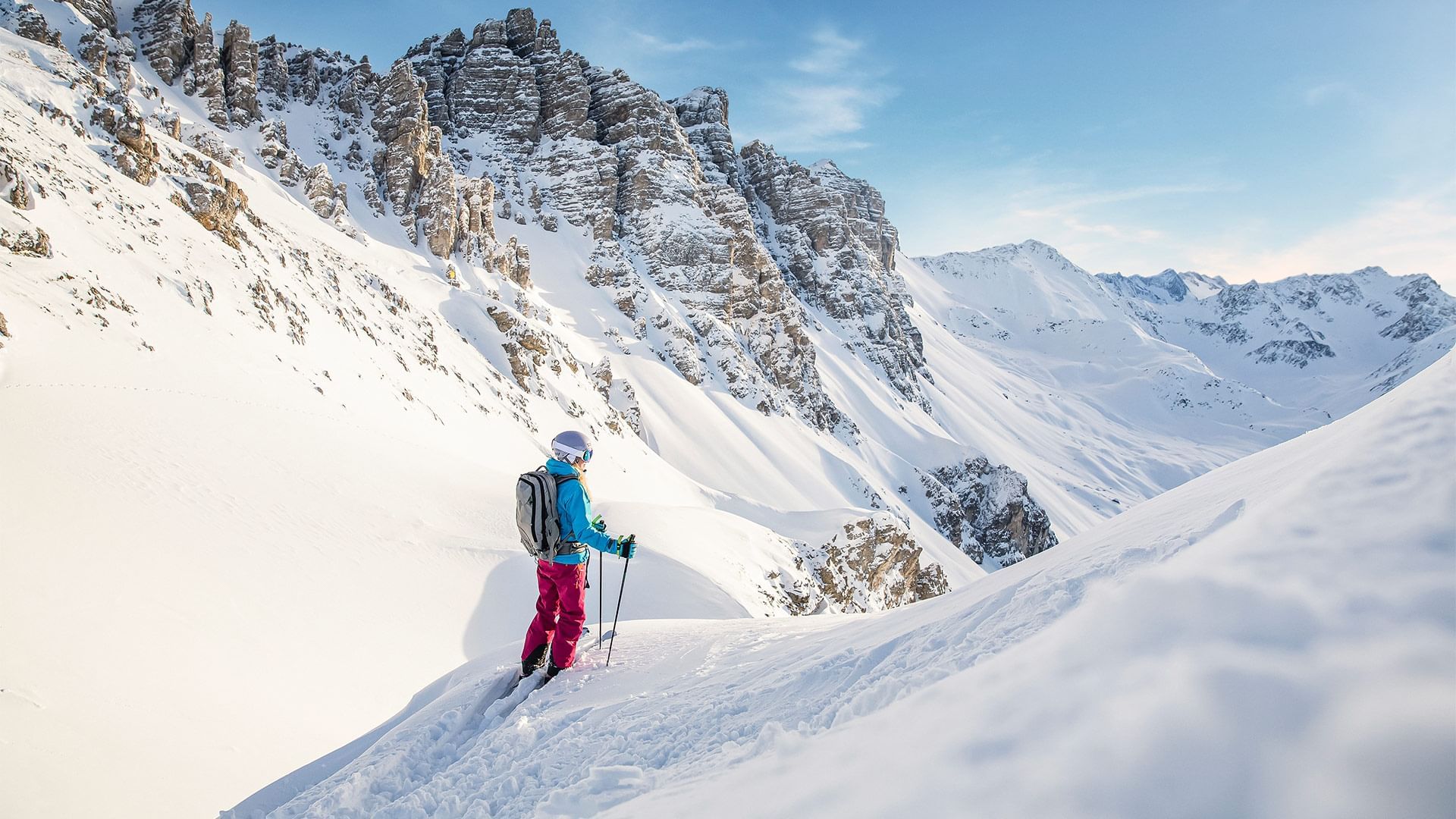 Skier on a snowy slope with mountain backdrop at Falkensteiner Hotels & Residences