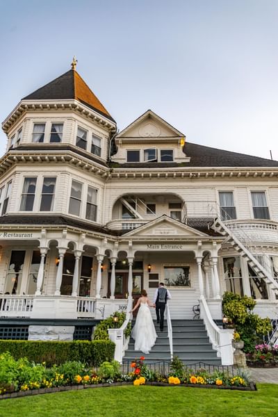 Bride and groom holding hands while walking up the stairs at Pendray Inn & Tea House