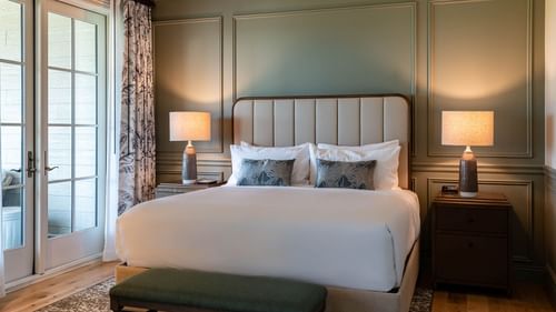 King bed with a cushioned headboard in Junior Golf Suite at Camp Creek Inn