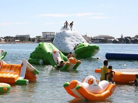 Just 4 Fun Aqua Park with inflatable slides and water play structures floating near The Sebel Mandurah