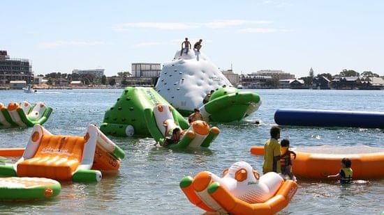 Just 4 Fun Aqua Park with inflatable slides and water play structures floating near The Sebel Mandurah