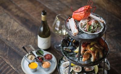Seafood platter with a wine bottle in Tony's, J House Greenwich, modern boutique hotel in Greenwich Connecticut