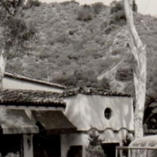 A black and white photo of traditional houses with tiled roofs in front of a hill near Catalina Island Company