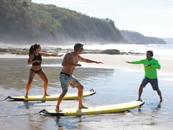A man training a couple to surf near Punta Islita Hotel