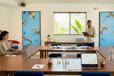 Art-filled meeting room at Vagabond Hotel Miami with U-shaped seating, presentation screen, and natural light, MiMo District