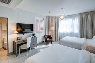 room with two beds, television and desk 