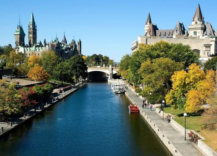 A picturesque view of the Rideau Canal surrounded by colorful trees and historic buildings near ReStays Ottawa