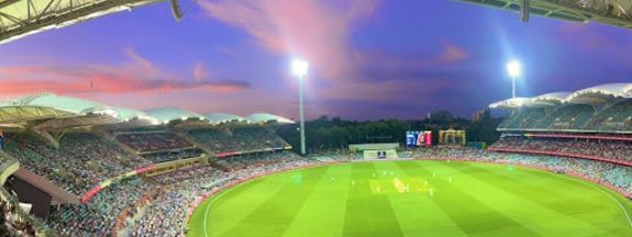 Panoramic view of Adelaide Oval at dusk filled with fans near Ibis Adelaide