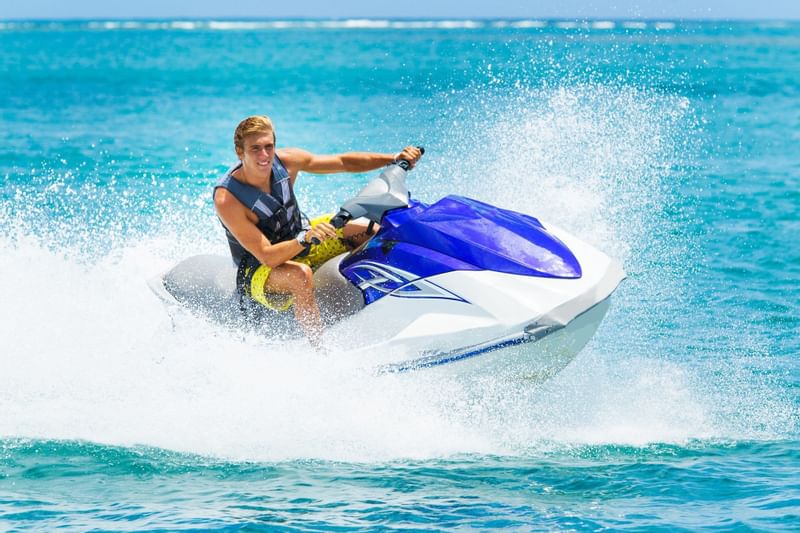 A guy riding a jet ski on the sea near The Diplomat Resort