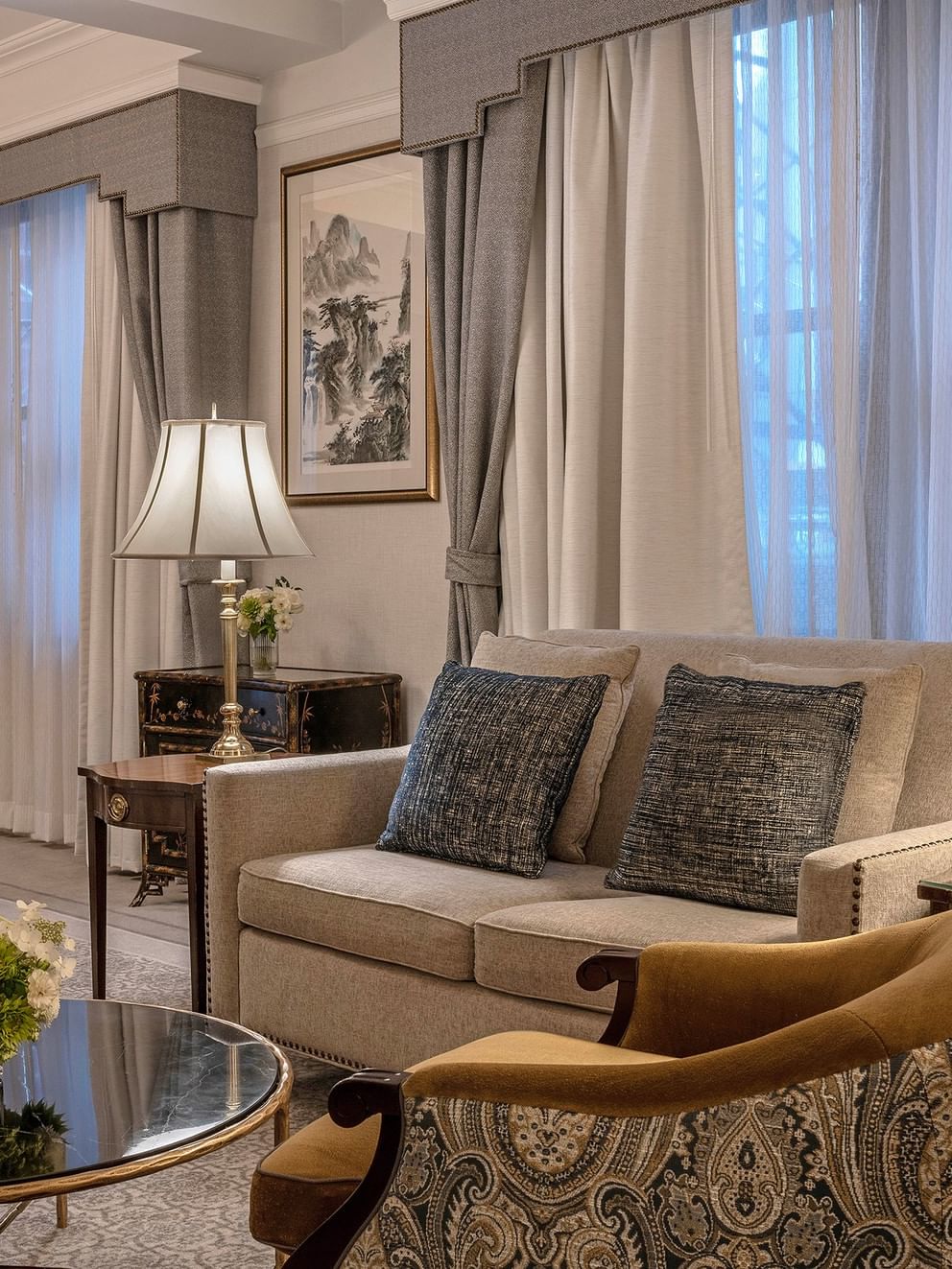 Elegant 54th Suite living area with couch, chairs, coffee table, and large windows at Warwick New York