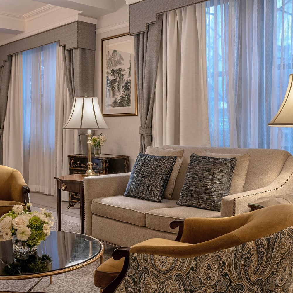 Elegant 54th Suite living area with couch, chairs, coffee table, and large windows at Warwick New York