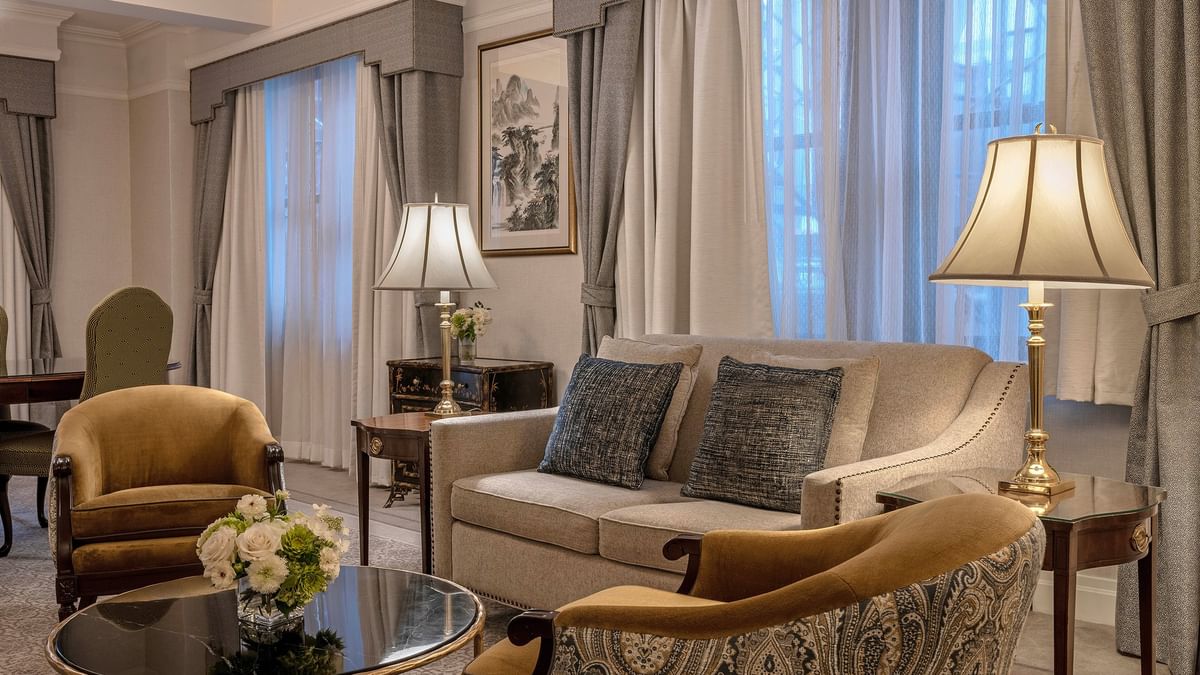 Elegant 54th Suite living area with couch, chairs, coffee table, and large windows at Warwick New York