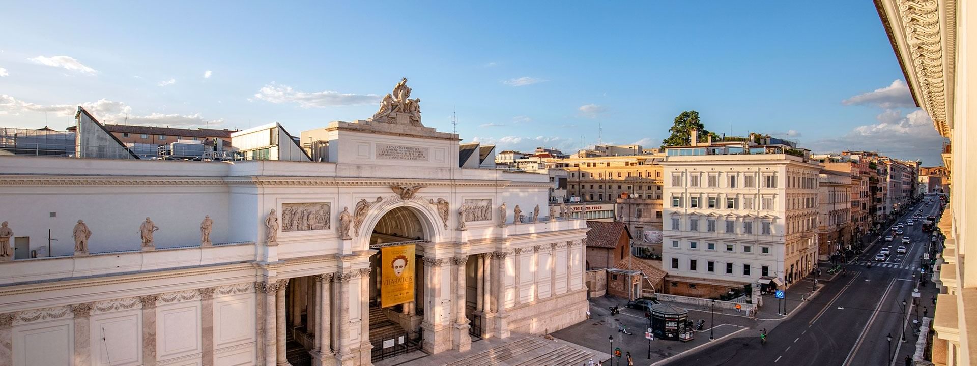 Elegant Palazzo delle Esposizioni with sculptural details and street view under a clear blue sky near AG Hotels