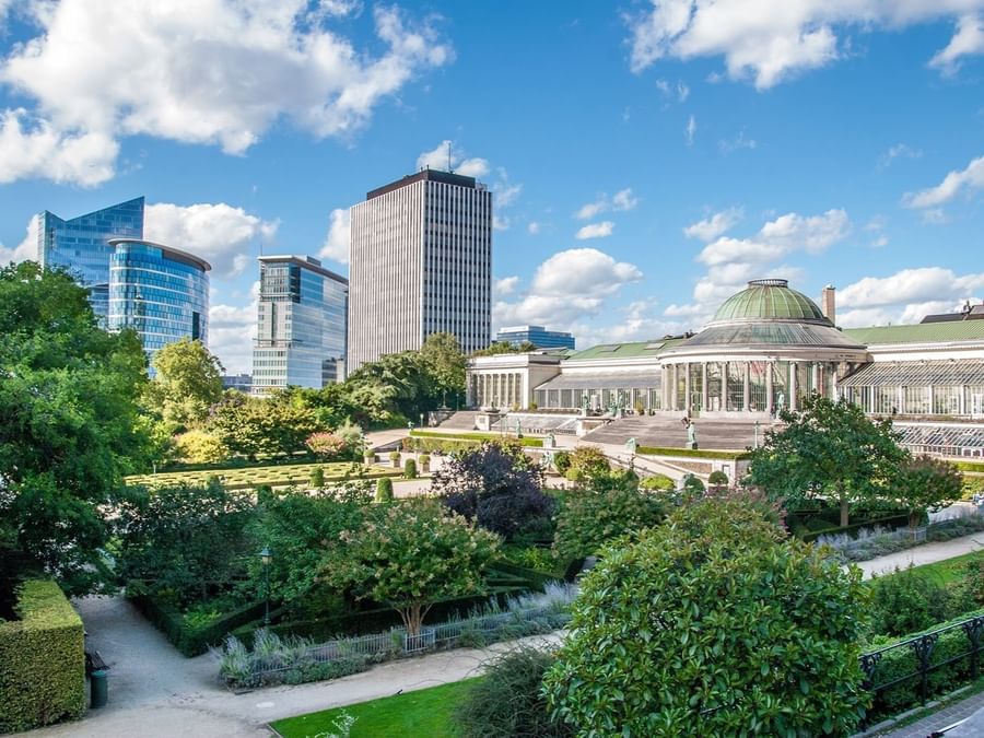 Uitzicht op een stadspark met hoge gebouwen op de achtergrond.