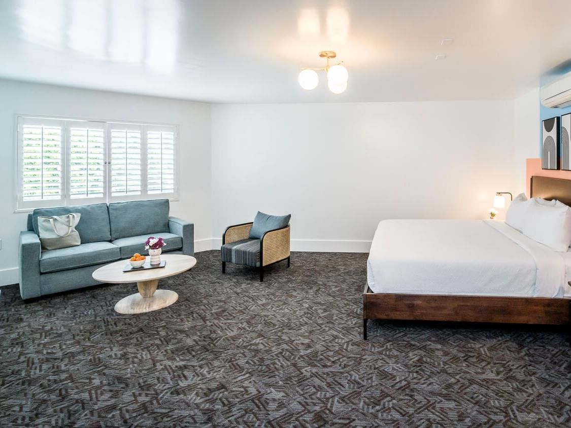 Bed and seating area with carpeted floors in King Suite at Beck's Motor Lodge San Francisco California