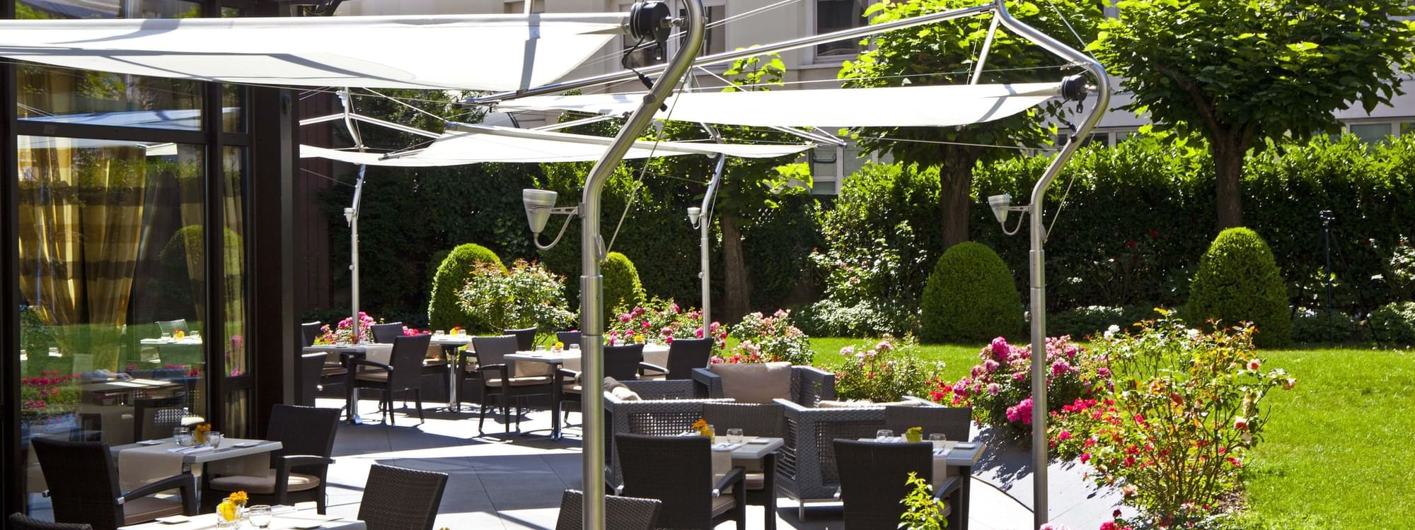 Dining tables arranged outdoors on a sunny day at Warwick Reine-Astrid