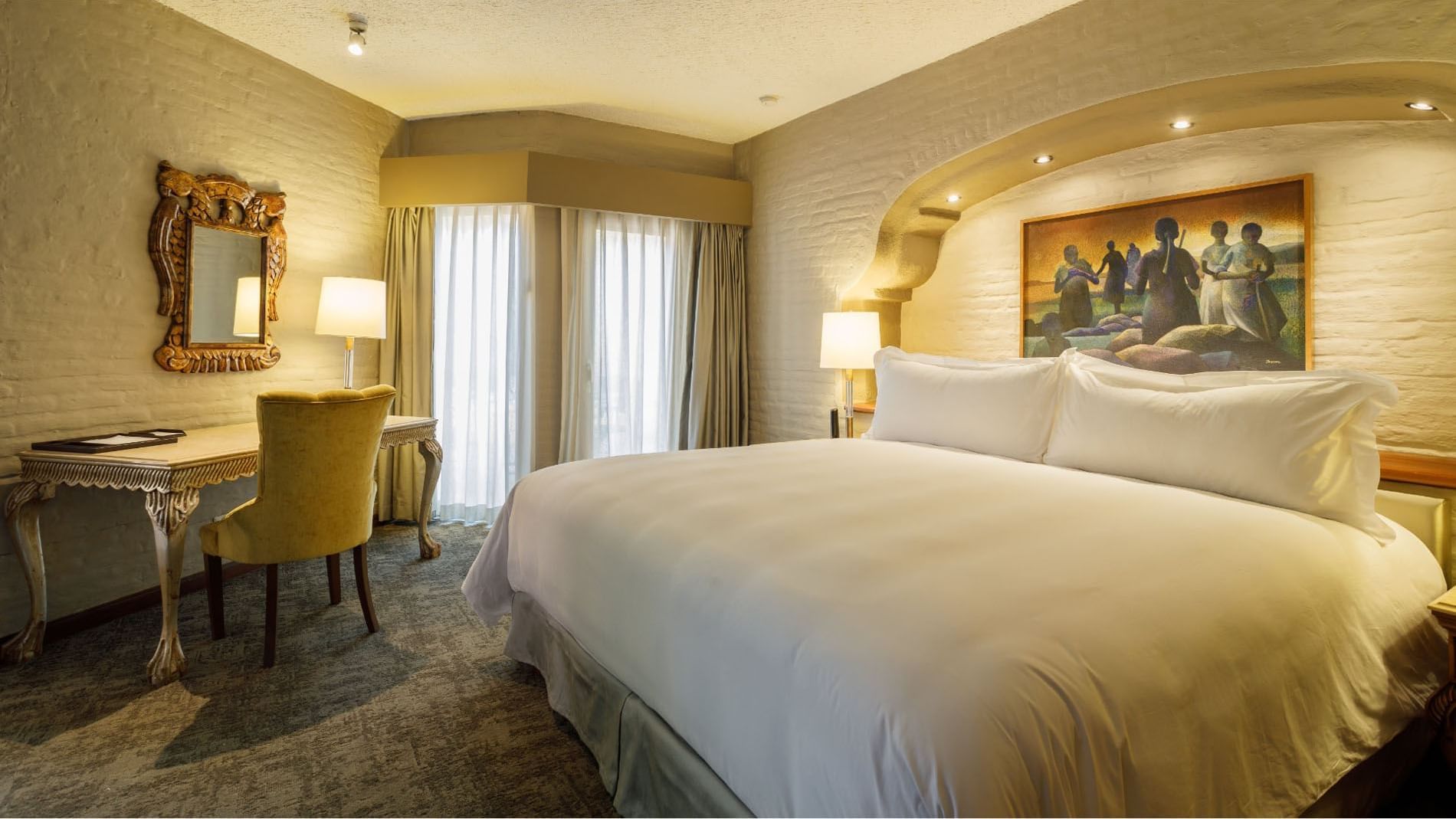 King Presidential Suite featuring a work desk, a yellow velvet chair, and textured stone walls at Quinta Real Guadalajara