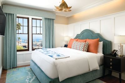 King-size bed by the window in Philip Knight Suite at Hotel Atwater