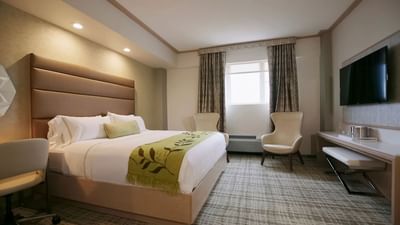 a bed and two chairs in a hotel room