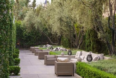 Outdoor lounge area with trees around at Luxe Sunset Boulevard Hotel