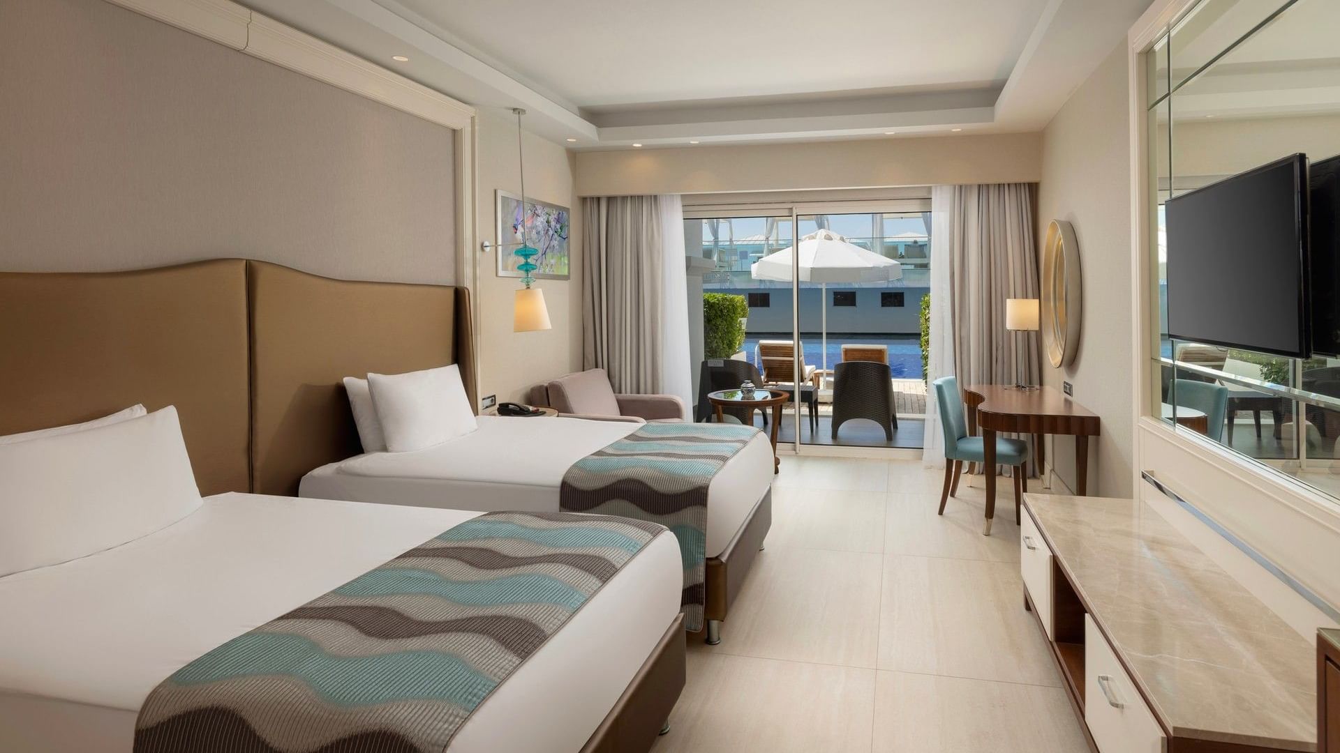 İki ayrı yatak, oturma alanı ve havuz manzaralı teraslı modern aile odası, Antalya'daki Titanic Deluxe Golf Belek.