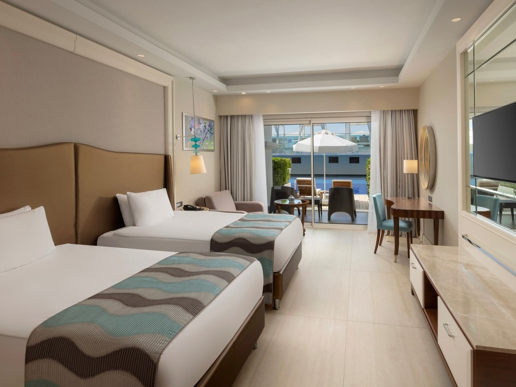 Modern hotel room with two twin beds, balcony access, and contemporary furnishings at Titanic Deluxe Golf Belek
