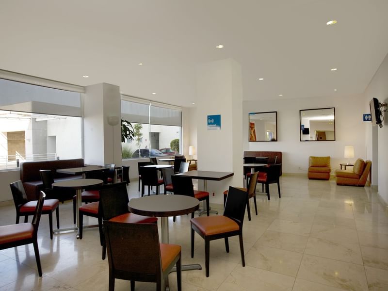 Mesas de comedor dispuestas en una sala de desayunos de One Hotels