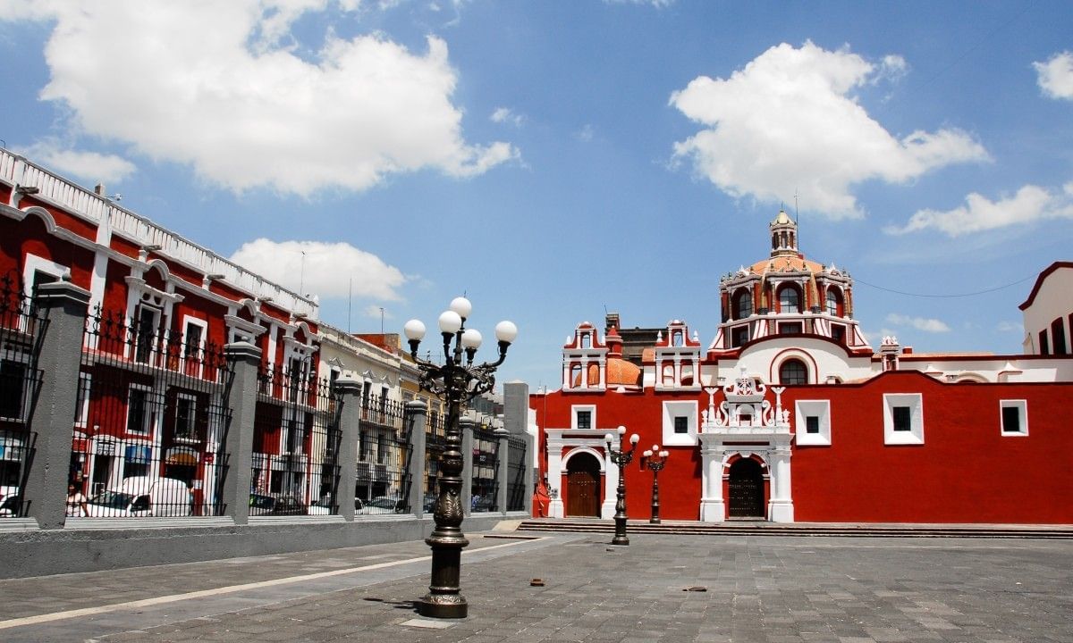 Street lamp by a red wall under a cloudy sky surrounding the courtyard at Camino Real Pedregal Mexico