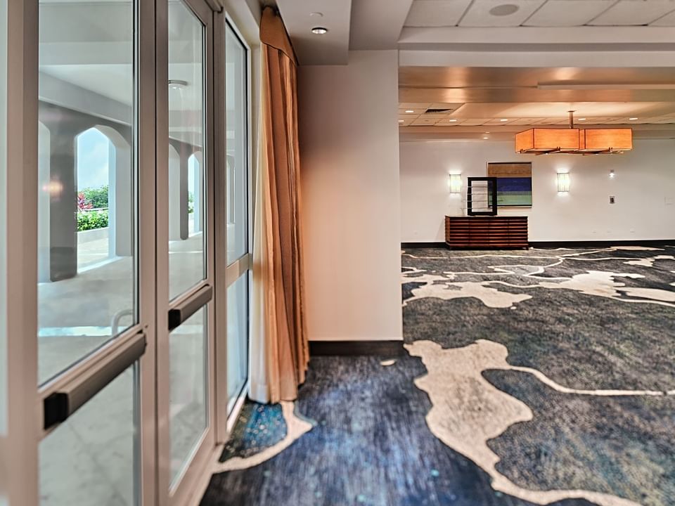 Interior of Icaco Breakout Room with windows overlooking the outdoor view at Las Casitas Village