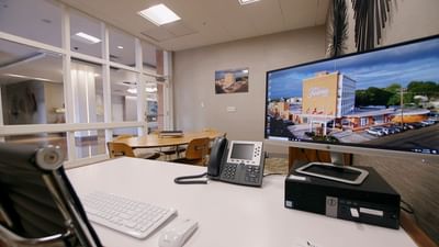 a computer screen and phone on a desk