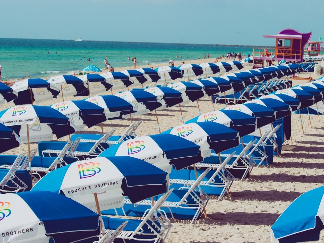 Rows of Sunbeds & umbrellas by the beach near DOT Hotels
