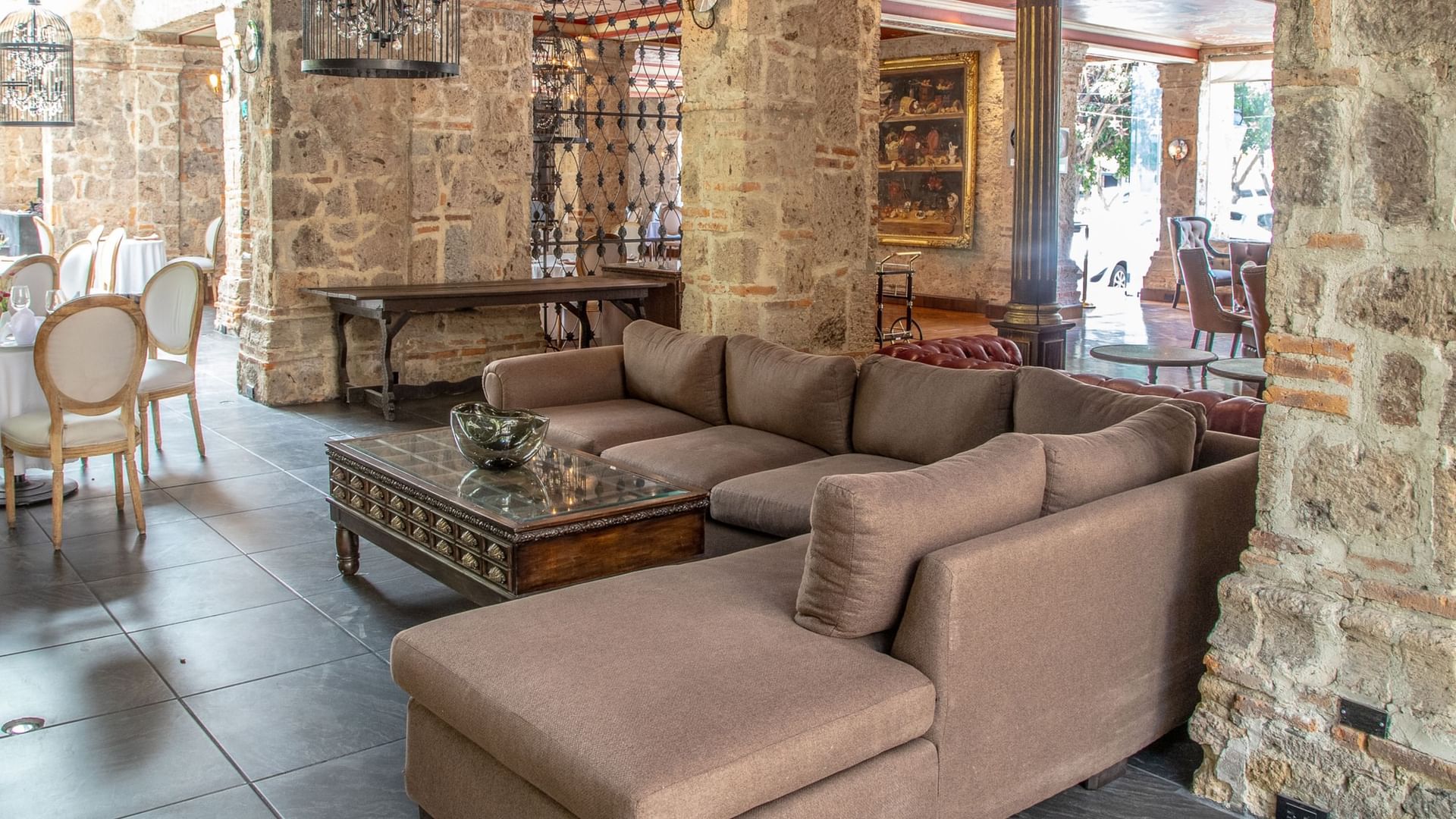 Elegant lounge area with stone columns, plush seating, and rustic decor at Tierra Mia, Quinta Real Guadalajara