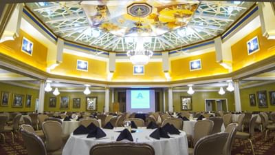 Ballroom with round conference tables and grand piano.