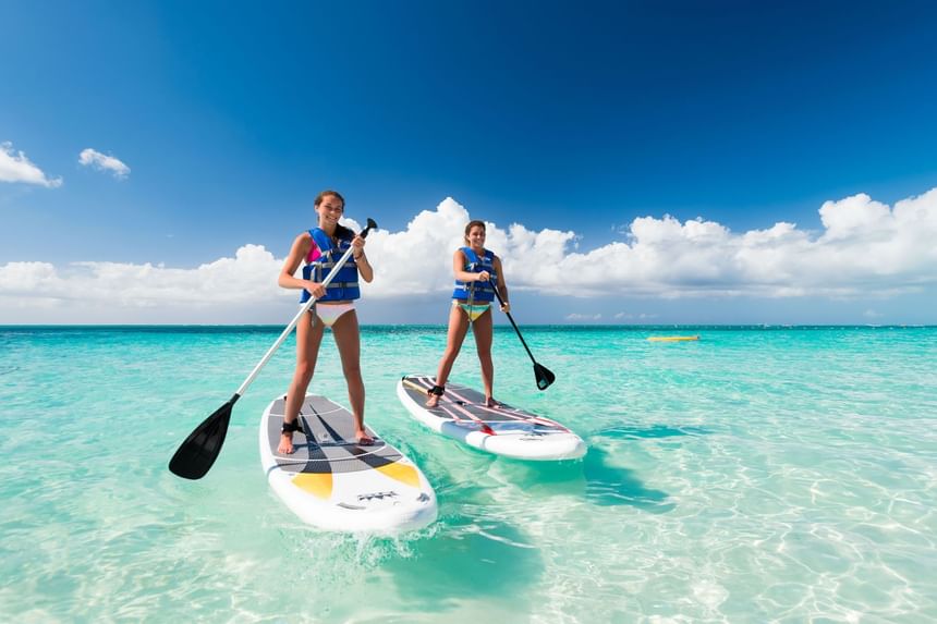Two girls paddleboarding near Windsong Resort On The Reef