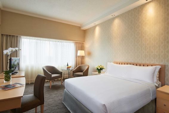 Workspace facing the bed in Superior Room with carpeted floors at York Hotel Singapore