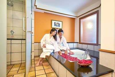 Couple enjoying a romantic rose petal bath in premium tower bathroom – Lexis Port Dickson