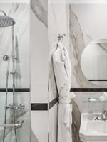 Executive Room bathroom featuring a marble vanity with a glass shower at Hotel Westminster Paris