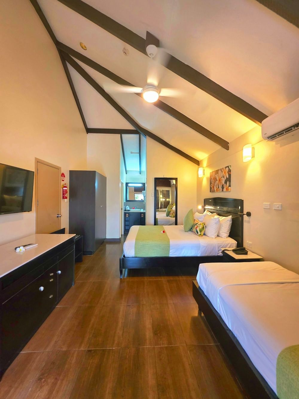 Studio Villa with vaulted ceilings and dark beams by a wardrobe and dresser at TokaToka Resort Nadi Fiji