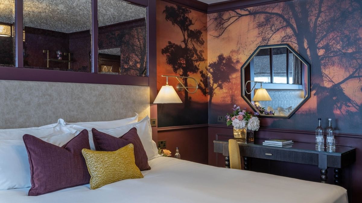 Elegant Executive Room with a large bed and scenic tree wallpaper at The Capital Hotel, Apartments & Townhouse