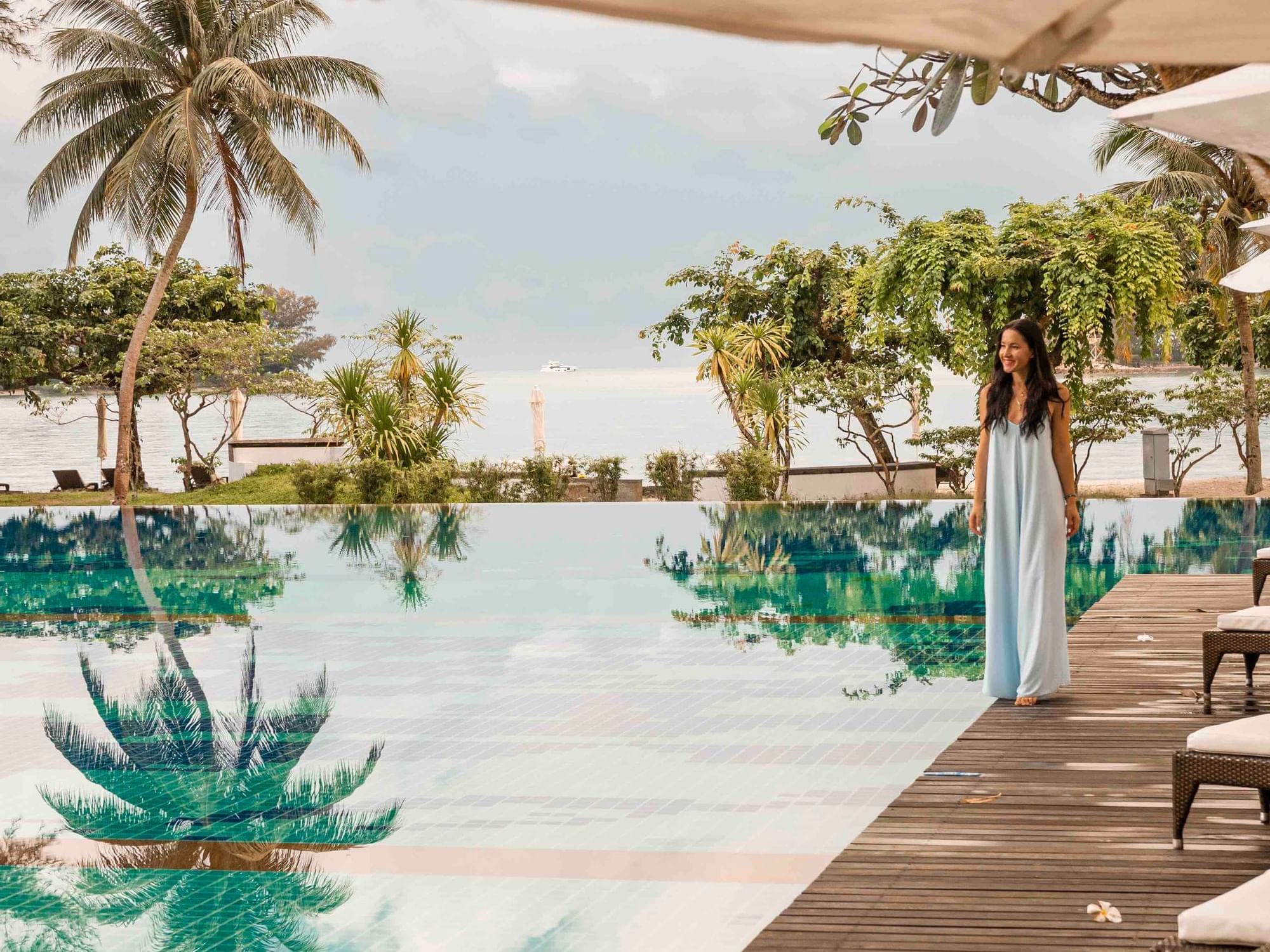 Lady strolling by the outdoor swimming pool overlooking the sea at Danna Langkawi Hotel