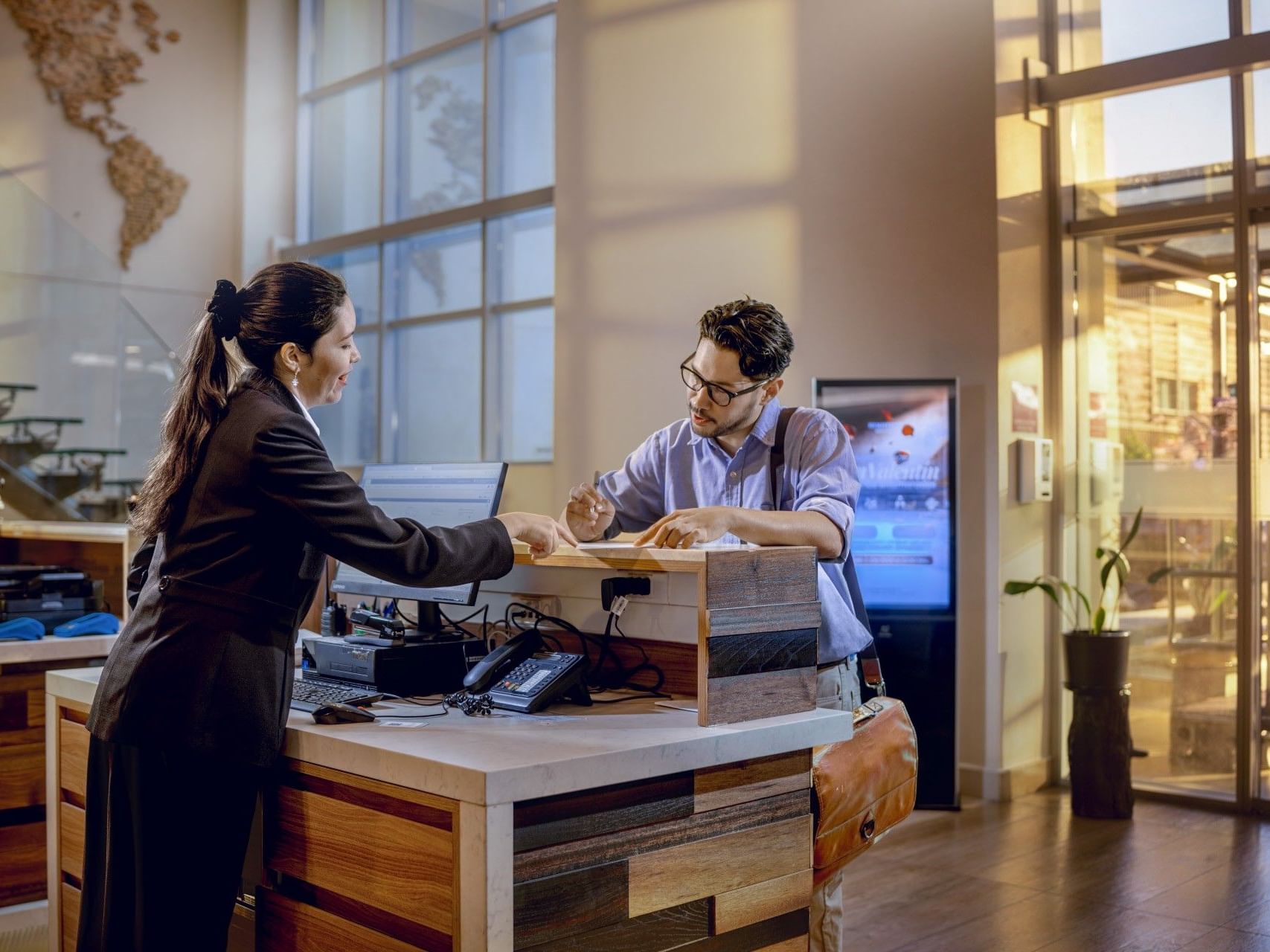 Una mujer se registra en la recepción de un hotel.